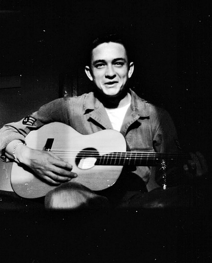 Johnny Cash holds his $10 guitar. He sold appliances door to door before auditioning for and signing with Sam Phillips at Sun Records in Memphis, Tenn.

