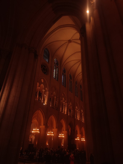 Vue sur le vaisseau central de la cathédrale plongée dans l'obscurité mais éclairée de spots orangés