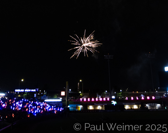 Burst of white yellow firework over the baseball field