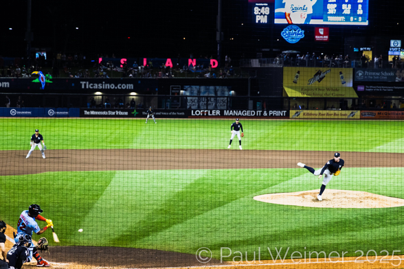 batter swinging at the pitch at a minor league game