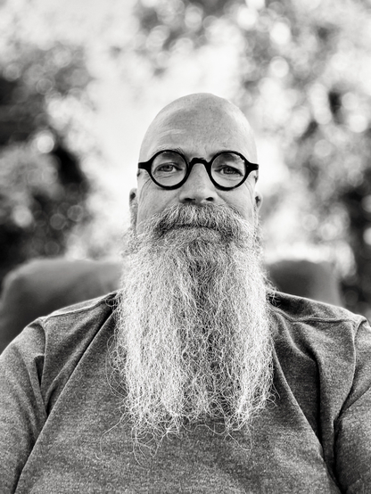 Portrait of a man with a long graying beard and a shaved head.