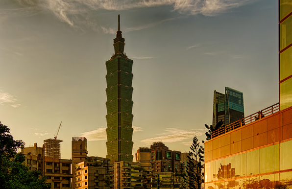 Taipei 101 and smaller residential and office buildings during sunset hour seen from the foot of Elephant Hill.