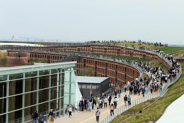 Diverse Wege mit Grünflächen und Scheinwerfern führen über den Ring.

Hinten links ist ein Teil des deutschen Pavillon zu sehen.
Ebenfalls weitgehend aus Holz erbaut. 