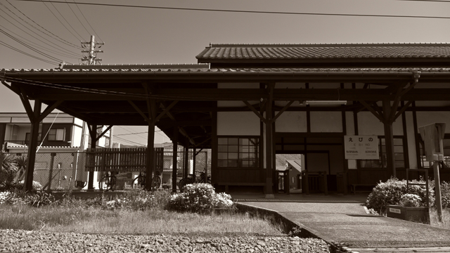 木造の古い駅舎が建っている.
写真はモノクロでセピア色に仕上げてある.