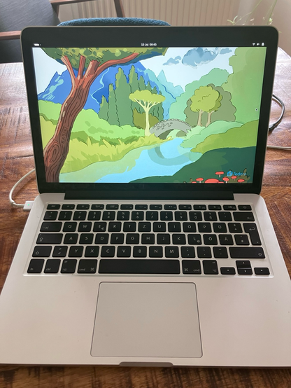 MacBook displaying fedora default wallpaper 