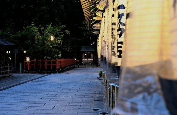 本殿の脇で明かりが灯されている提灯と、中央奥の小さな社。/ 2025.07.19 八坂神社から