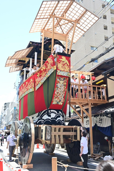 大船鉾の正面。復興してまもなく(10年ほど)ということもあり、船鉾と比べて懸装品は控えめ。骨組みの木々も新しさを感じさせる。/ 2025.07.20 四条町から