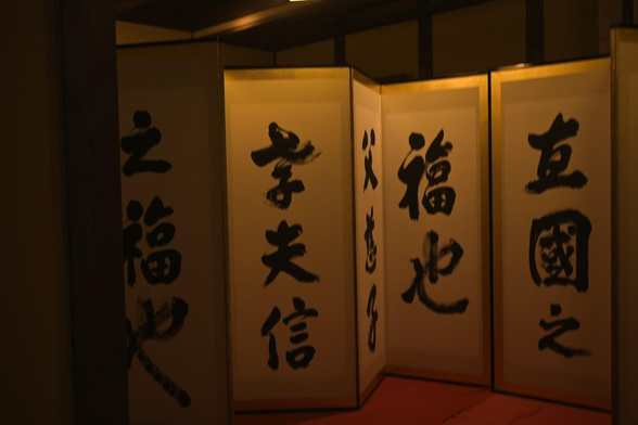 1枚目の写真と同じく、天台宗の僧で書家の宮小路浩潮による。六曲左隻。「福也父慈子孝夫信妻貞家之福也」と書かれている。最後の一曲に署名があるんだけど、その部分は柱に隠れている。/ 2025.07.22 新町通・三条町から