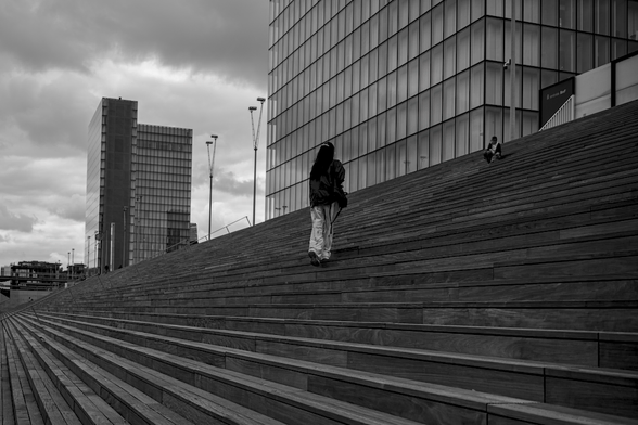 Monochrome daylight urban landscape photography.
Towers in the city witnessing human encounters on the steps of the grand staircase.