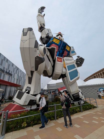 Gundam Roboter türmt sich vor einem auf.