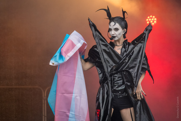 Bambie Thug holds up the transgender flag on stage.