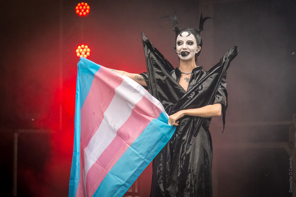 Bambie Thug holds up the transgender flag on stage.