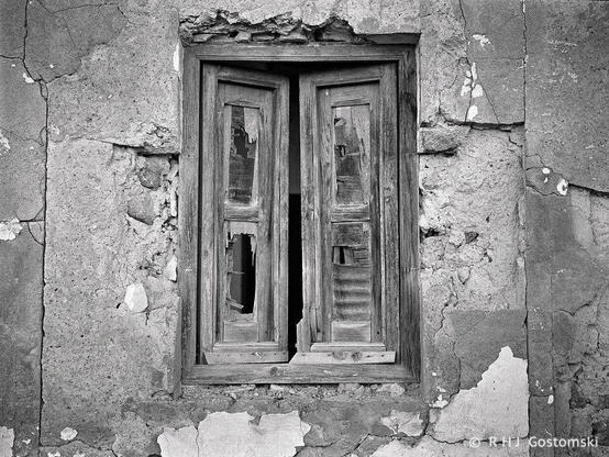 Old wooden shutters exhibiting decay in an abandoned building. 