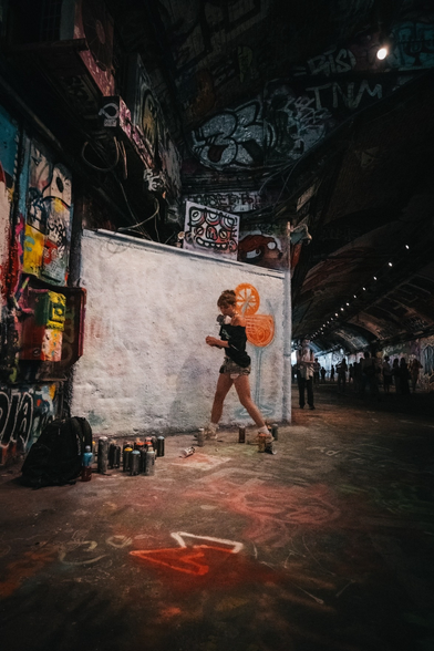 An artist specializing in graffiti is creating artwork.