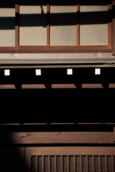 Shadows and light play across the wooden architecture of a traditional building.