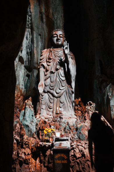 A budha statue in a temple set in a cave set somewhere in Vietnam