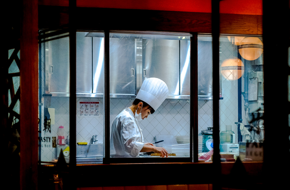 Cuinera feinejant a la cuina d'un restaurant