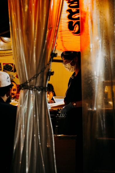 photo of a female chef working behind a counter in a very small restaurant