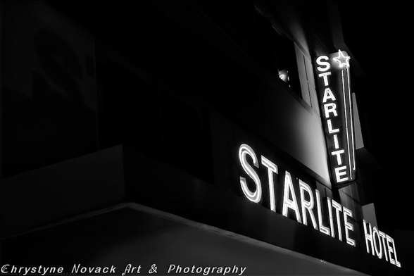 A neon sign spelling out "STARLITE HOTEL" glows prominently against a dark background, with the light casting a soft illumination on the building's facade. Vertical and horizontal lines from the building's edges and the sign's structure create a contrasting and dramatic angular composition.

The magical glow of the Starlite on Ocean Drive is just one of the many eye-catching neon signs that can be seen all along the Art Deco District in South Beach. The Art Deco District has a line of hotels and buildings showcasing the 1930's art deco architecture.