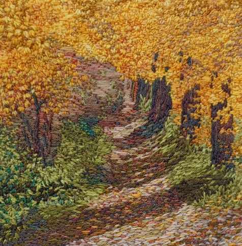 Stitched artwork depicting a path through autumnal woodland.