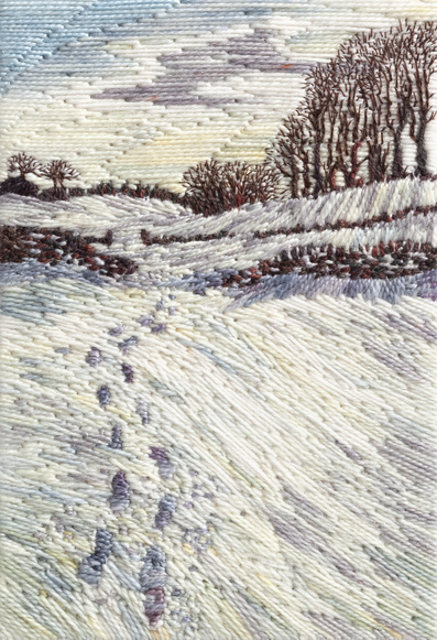 Stitched artwork depicting a snow scene with bare trees on the horizon. A stone wall crossed the centre and footprints kead through a gateway in it