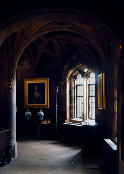 picture taken inside a castle showing arches lit by a bright window