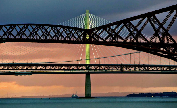 A dusky sunset starts behind the bridges on the Forth, north of Edinburgh. The new bridge's lights had just come on helping to give definition to the new structure behind the classic forth rail bridge