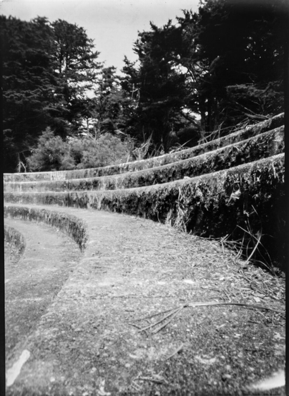 A close-up of a circular stair sweeping away from the camera. A black and white photo taken with a pinhole camera on a paper negative