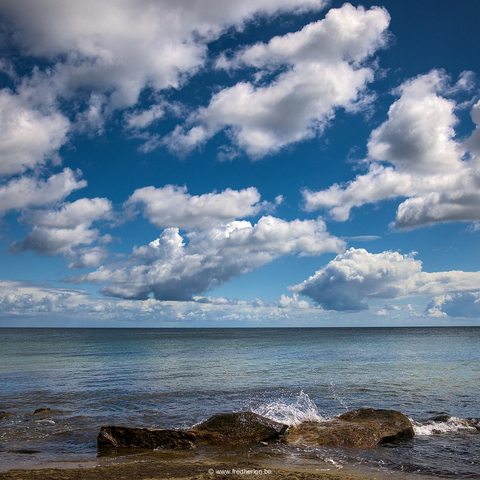 Vue de la mer Baltique. A l'avant plan trois rochers sur lesquels une petite vague vient se briser. Dans le tiers bas une étendue de mer calme aux reflets vert-turquoise, dans les deux tiers du haut un ciel azur parsemé de nuages blancs
-
View of the Baltic Sea. In the foreground, three rocks on which a small wave breaks. In the lower third, a calm expanse of sea with turquoise-green reflections; in the upper two-thirds, an azure sky dotted with white clouds.