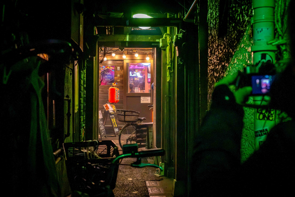 Carrer estret que desemboca en un bar a Kabukicho, il·luminació de nit.