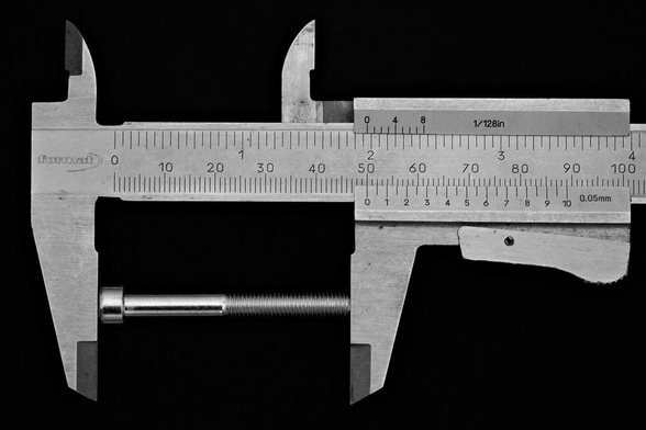 Ausschnitt eines Meßschiebers vor schwarzem Hintergrund. Zwischen den Backen ist eine Imbusschraube, die genau 50mm lang ist. Auch bei der 0,05mm Skala steht die 10 auf dem Strich.
Die Schraube hat nur zur Hälfte Gewinde und ist etwas blanker als die gebürstete Oberfläche des Meßschiebers.