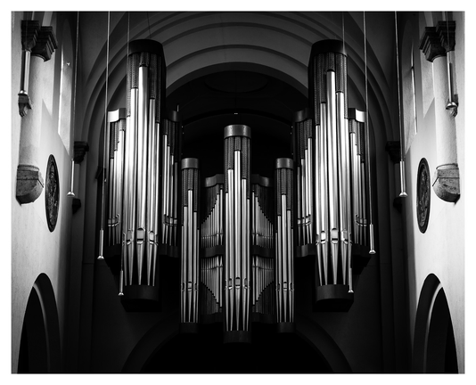 Die metallisch glänzenden Pfeifen einer Kirchenorgel als sehr knackiges Schwarz/Weiß-Bild.