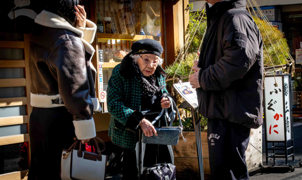 Dona gran flanquejada per la seva família a la sortida d'un restaurant. 