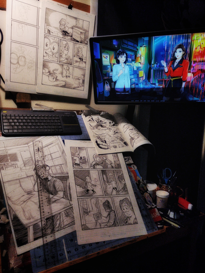 The artist's drawing board, the surface and the corkracks above all covered in pages of comic art. A Jack Hamm reference book is pinned to the top of the drawing board next to a wireless keyboard, and a translucent ruler sits on top of one of the pages. A monitor hovers above the drawing board, with a scene from the visual novel A Summer's End: HK 1986 on the monitor. One of the characters is telling the other, "Coke? I have coke."