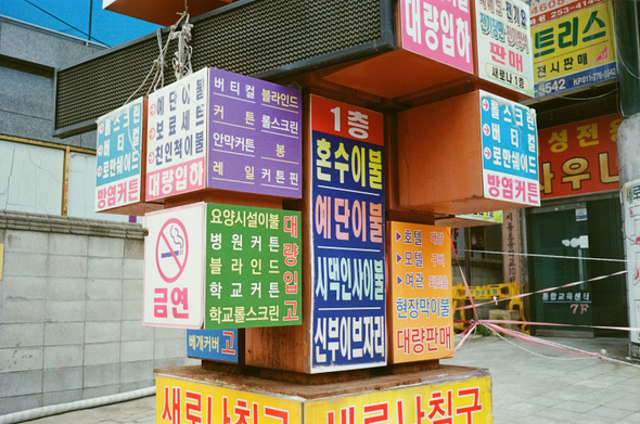 네모난 블럭들이 여기저기 붙은 것처럼 각양각색의 네모난 간판들이 기둥에 붙어있다.