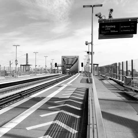 Eine S-Bahnstation an der die nächste S-Bahn in Richtung Pinneberg geht. Man sieht die Gleise in diese Richtung sowie rechts auf dem Bahnsteig sind Pfeile auf dem Boden zu sehen. Rechts oben steht das Schild auf dem dann steht das die nächste S-Bahn in Richtung Pinneberg geht.