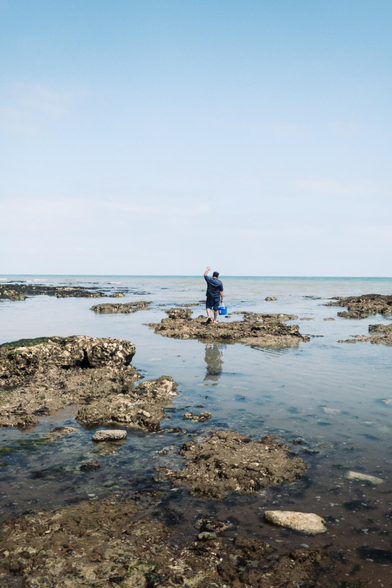 A beachside environmental portrait of a male subject has been captured.
