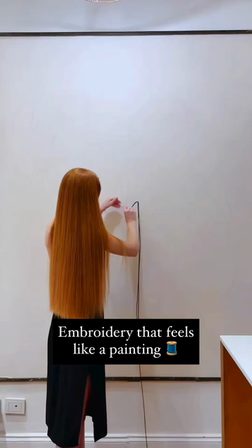 Video of a person who does large scale embroidery, creating painting like works.