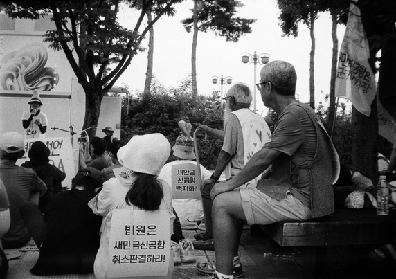 새, 사람 행진에 참여한 시민들이 진위역 광장에서 문화제를 하는 모습. 사진 속 지팡이를 짚고 앉은 사람은 문정현 신부.
