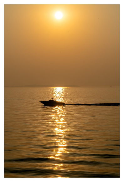 Diesige Sonne, glitzernder See, Motorbootsilhouette