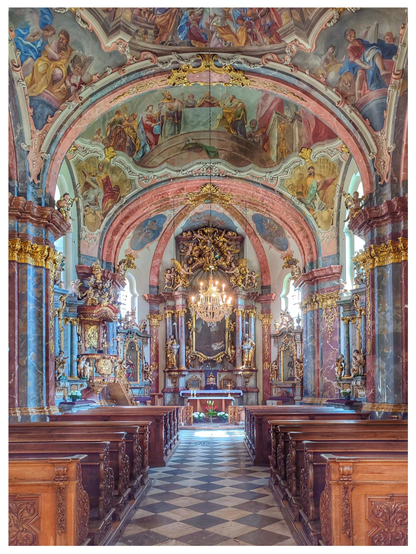 Farbfoto im Hochformat mit weißem Rand. Zu sehen ist der Innenraum einer katholischen Kirche. Alle Wände, Decken und Säulen sind mit biblischen Motiven bemalt, die Farben sind rosa, gold, hellgrün und hellblau. Der Fußboden besteht aus hellen und dunklen Fliesen.