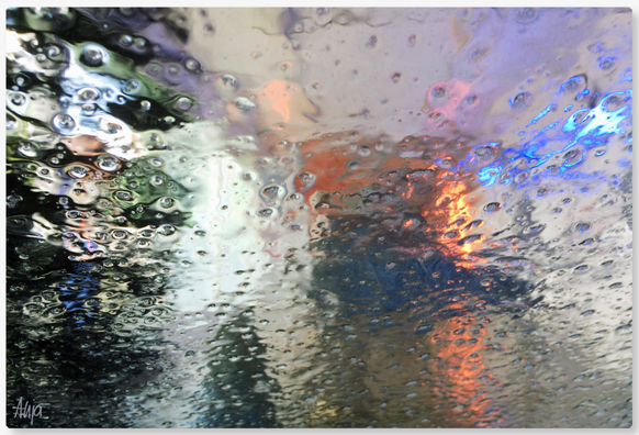 Mit dem Auto durch die Waschanlage: Lichter der Anlage und eines vorausfahrenden Autos werden von der nassen Fensterscheibe reflektiert. Die Farben sind grün-grau über orange-rot und viel grau-weiß, durch die Tropfen wirkt das Foto sehr abstrakt. 

Driving through the car wash: the lights of the car wash and a car in front are reflected in the wet window pane. The colours are green-grey over orange-red and lots of grey-white; the raindrops make the photo look very abstract. 
