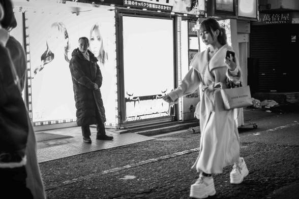 Noia amb gavardina blanca i sabates esportives de doble sola caminant pels carrers de Kabukicho, Tòquio