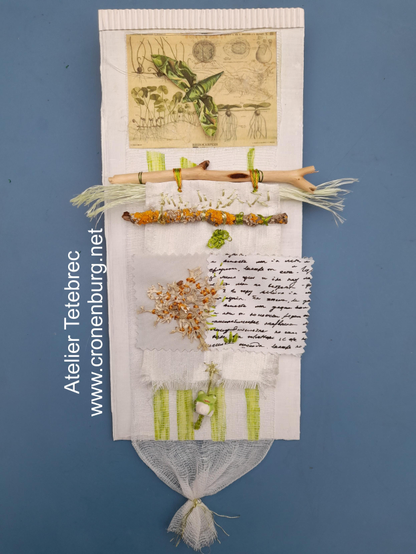 A hanging collage in green, white and orange tones with natural finds. The most important parts of this abstract collage are wooden sticks (one with a bright orange lichen), a real lichen with embroidery stitches in silk yarn, a small porcellaine frog and a historic illustration of water plants.