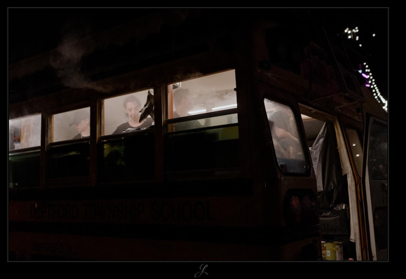 View of the back of a food truck, taken at night. The windows are somewhat fogged and illuminated from the inside, above one of the windows comes a cloud of steam from the kitchen. People who work inside the truck can be seen by the fogged windows. On the right is the rear door of the truck, it is open. The surrounding is dark, only a blurred light chain can be seen in the upper right corner of the image.

AI disclaimer: Using my work, its meta data, written or derived description to create media with or train AI based systems is prohibited.