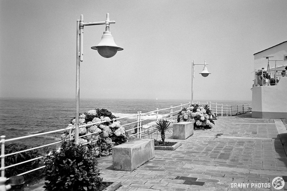 A black-and-white film photo of the seafront promenade in Rinlo