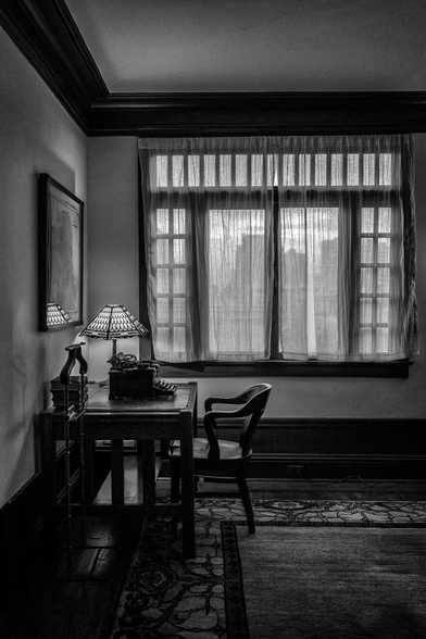 Desk with lamp and typewriter by a curtained window in a San Francisco apartment decorated with furniture from the 1920s.