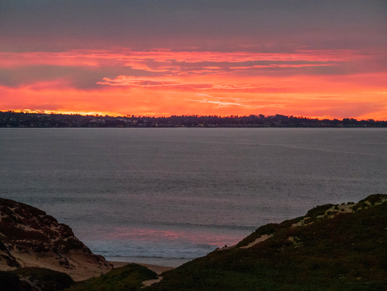Pink clouds over the peninsula across the water after the sun had set
