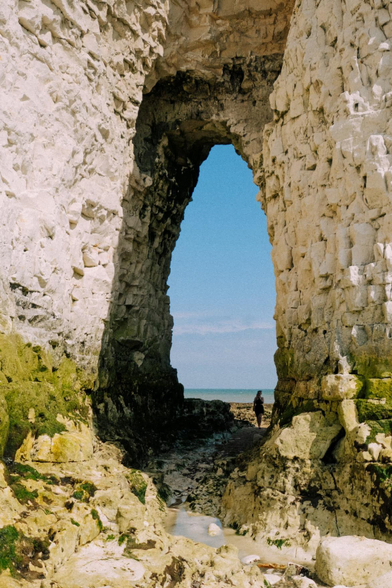 An image depicting a cliff face, including a human figure to provide a sense of scale.