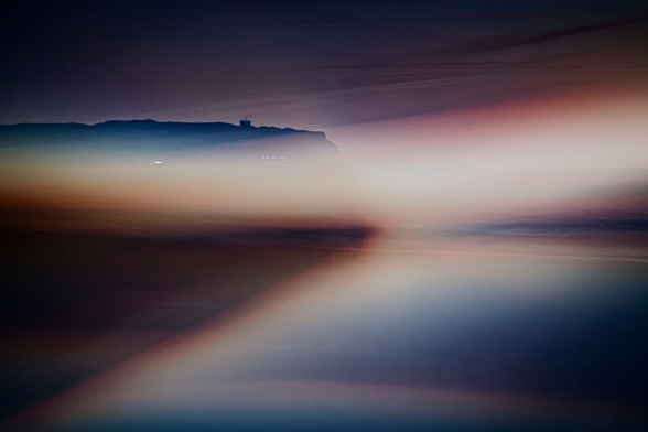 In the background, the rocks of Heligoland. The light of the setting sun blurs across the entire image due to the moving camera.
